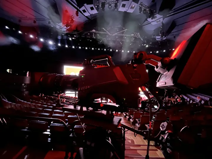 Studio camera in an event hall with stage lighting